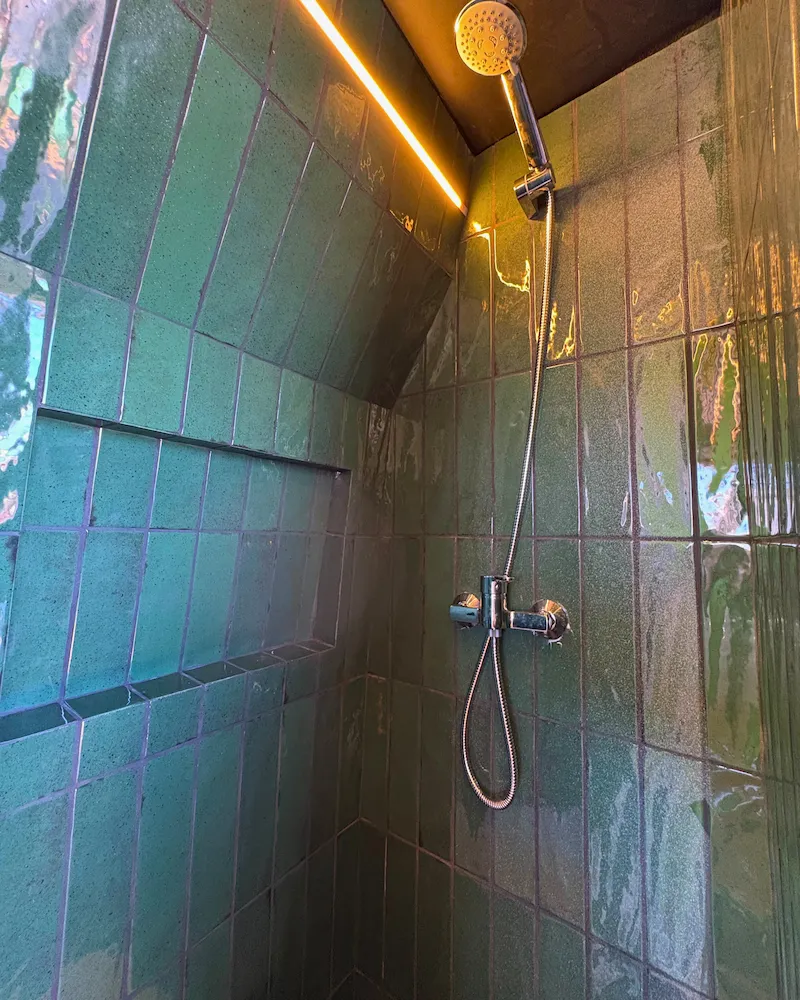 Douche moderne avec carrelage vert dans van Renault Master, espace bien-être tout confort en itinérance.