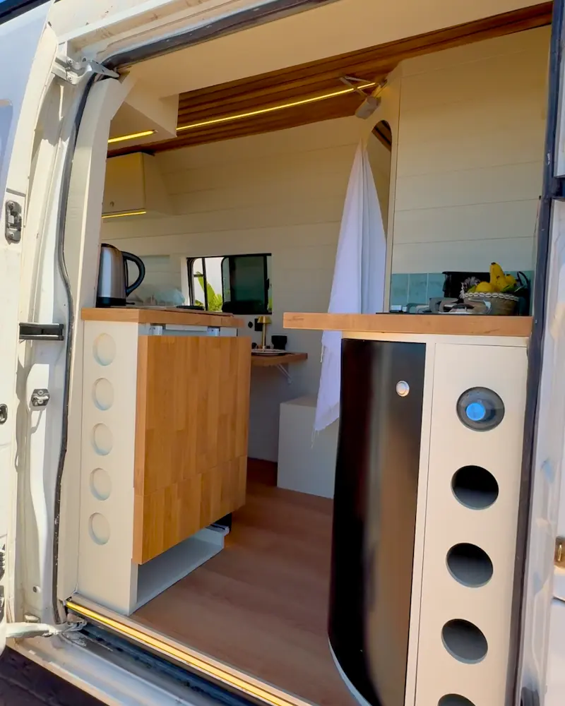 Entrée du van Renault Master aménagé avec cuisine et douche, intérieur design pour road trip au Maroc.